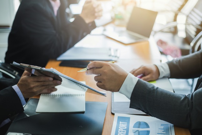Business professionals shaking hands across a meeting table