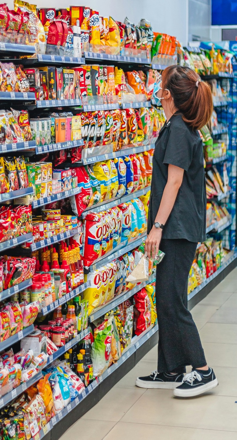 Shopper browsing products on a supermarket shelf